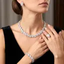 Luxurious floral-themed set consisting of a necklace, earrings, ring, and bracelet, crafted from rose-shaped zircon stones and rhodium plating.