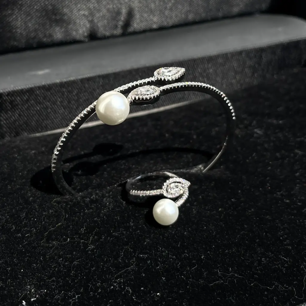 Luxury bracelet and ring adorned with pearls and teardrop-shaped zircon stones, rhodium plated.