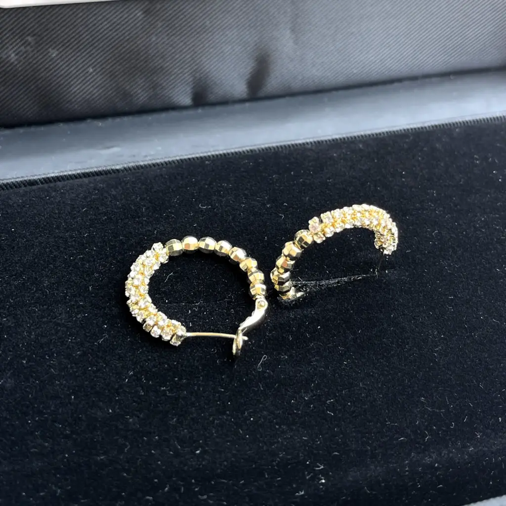 Luxurious gold hoop earrings adorned with cubic zirconia stones and beads, plated with rhodium.