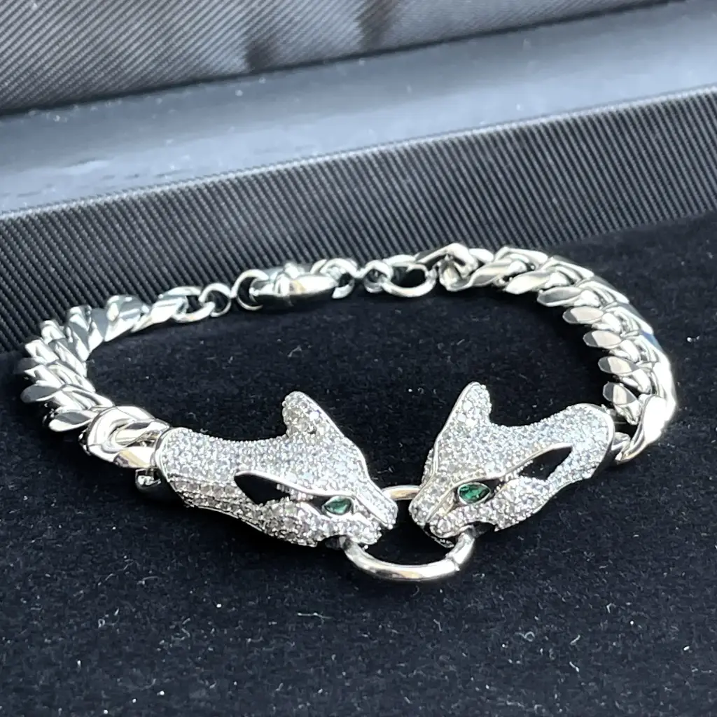 Luxurious silver chain bracelet adorned with two tiger-head shaped zirconia stones, plated with rhodium.
