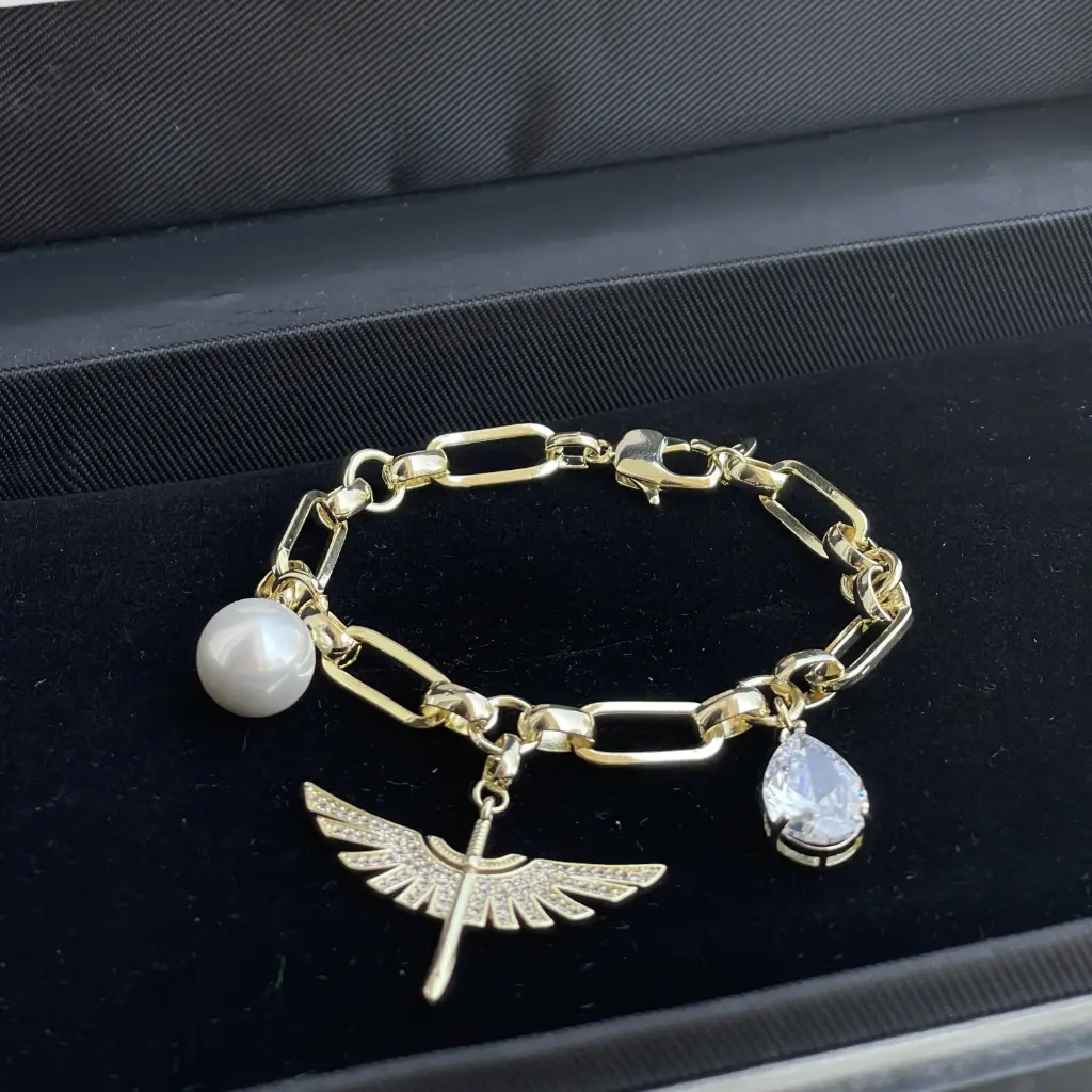 Luxurious gold-plated rhodium bracelet in the shape of an eagle, pearl, and precious stone, adorned with zirconia stones.